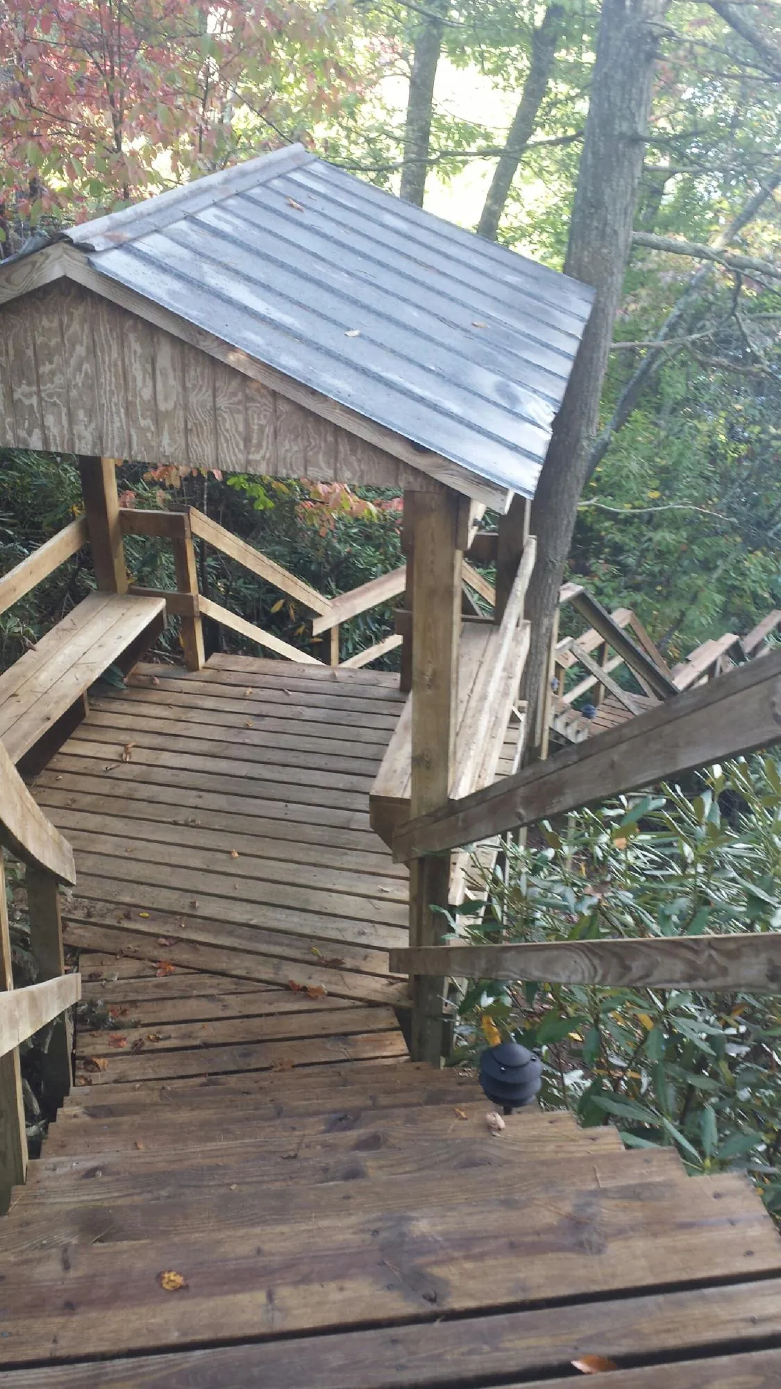 Metal roofed shelter over wooden steps on a wooded walkway — Skylight Repair & Installation work by our crew in Hubbardston